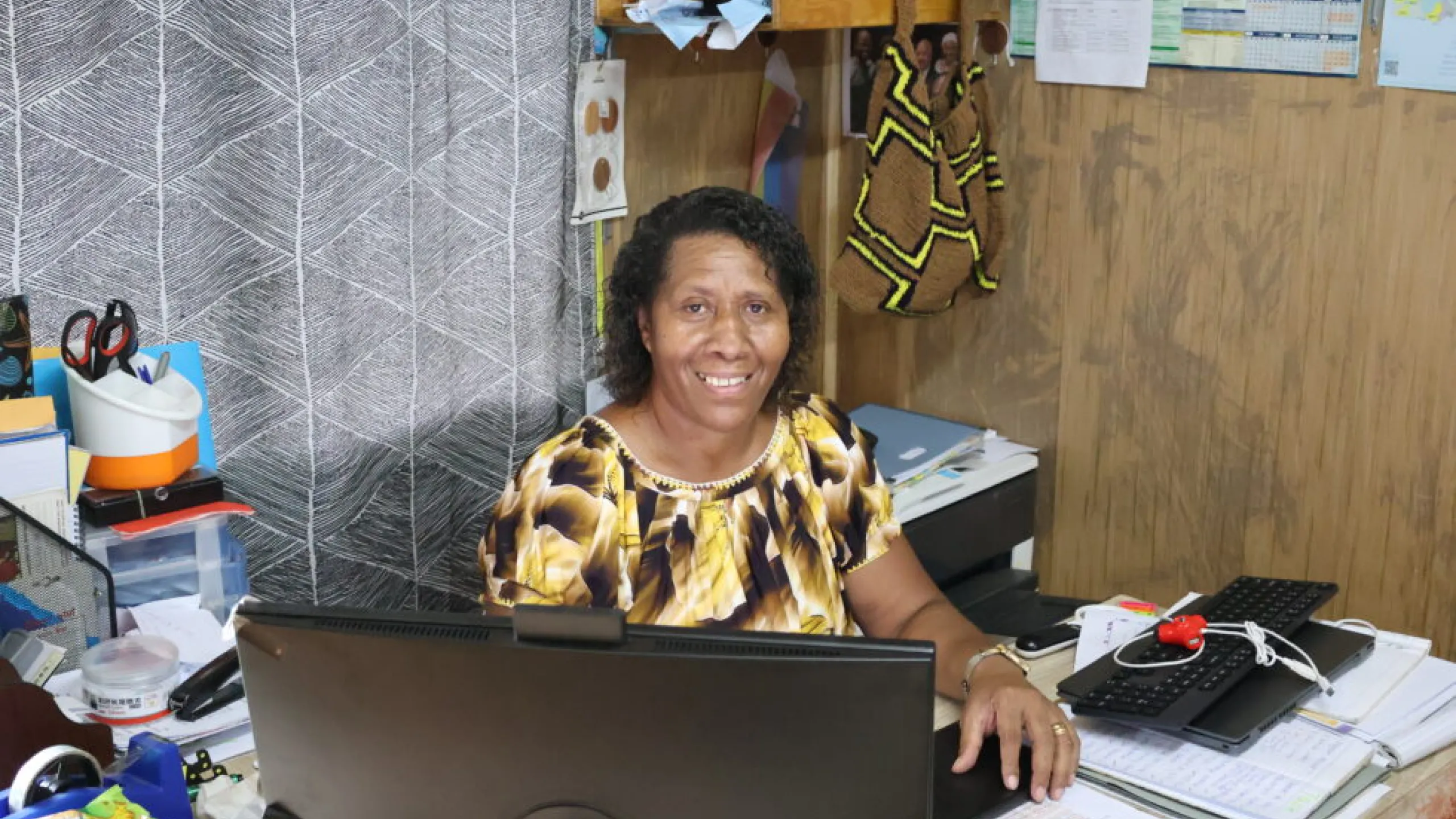Jean Jano at desk smiling at camera